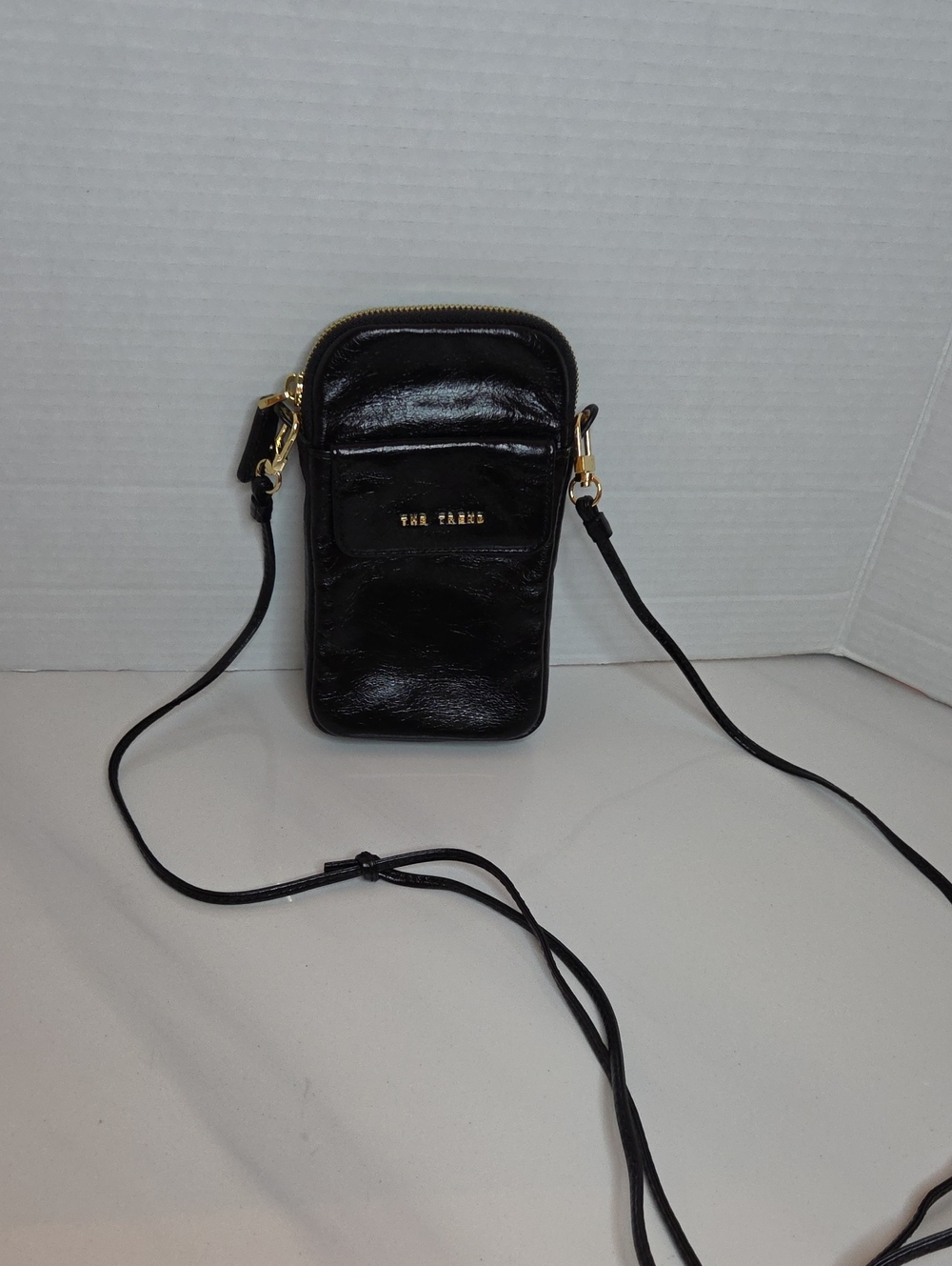 The Trend Black Patent Crossbody Phone Pouch with Gold Hardware